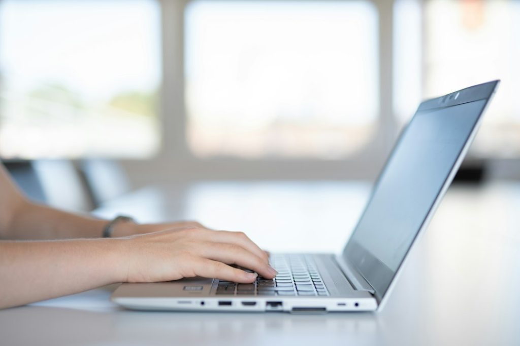 Person using laptop as illustration for Outlook incoming email troubleshooting