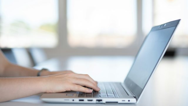 Person using laptop as illustration for Outlook incoming email troubleshooting